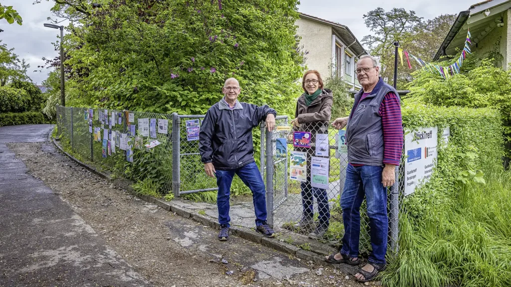 Drei Mitglieder des Quartierleists vor einem Zaun