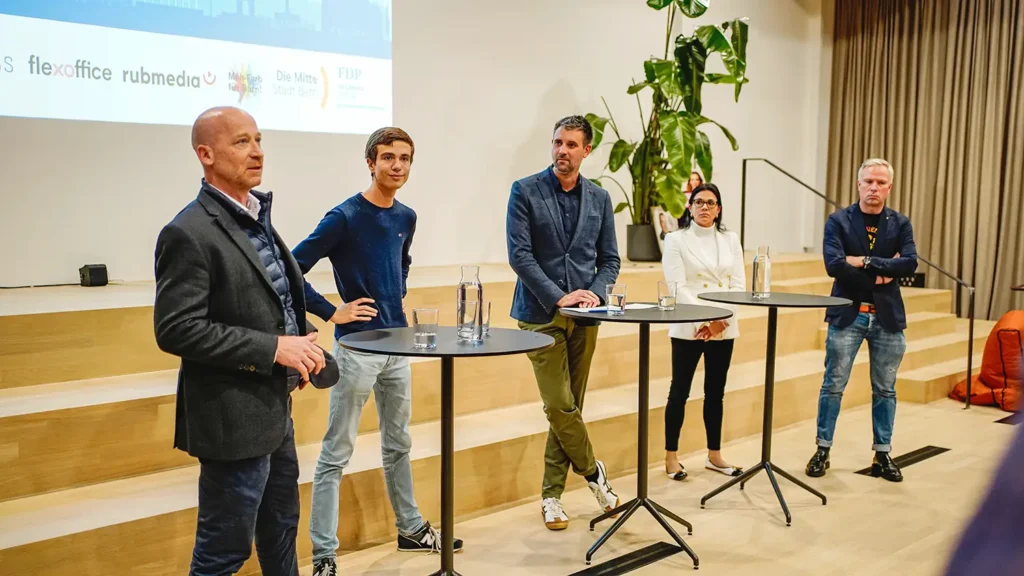 Das Podium mit den Stadtratskandidierenden der GLP, Jungfreisinnigen, SVP, Die Mitte und Moderator Yves Schott